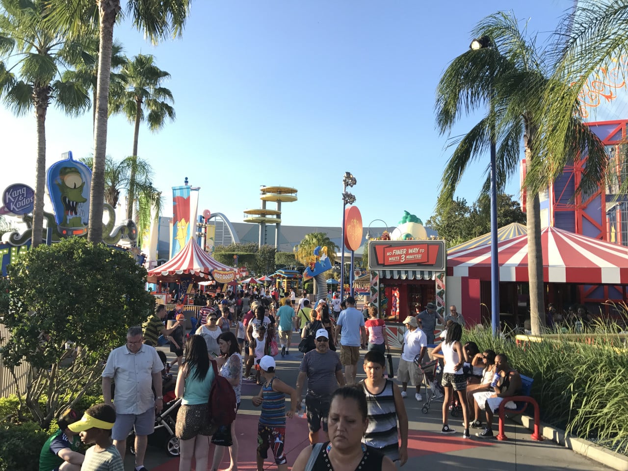 Davy v Universal Studios Orlando s palmami, stánky a davy návštěvníků v Simpsons zóně