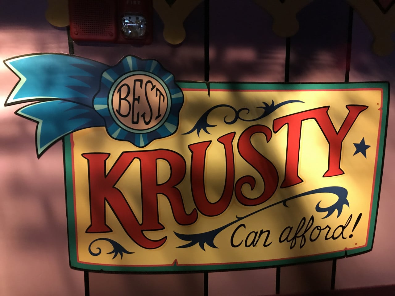 Barevný nápis Krusty Can afford! z Jurského světa na stěně parku