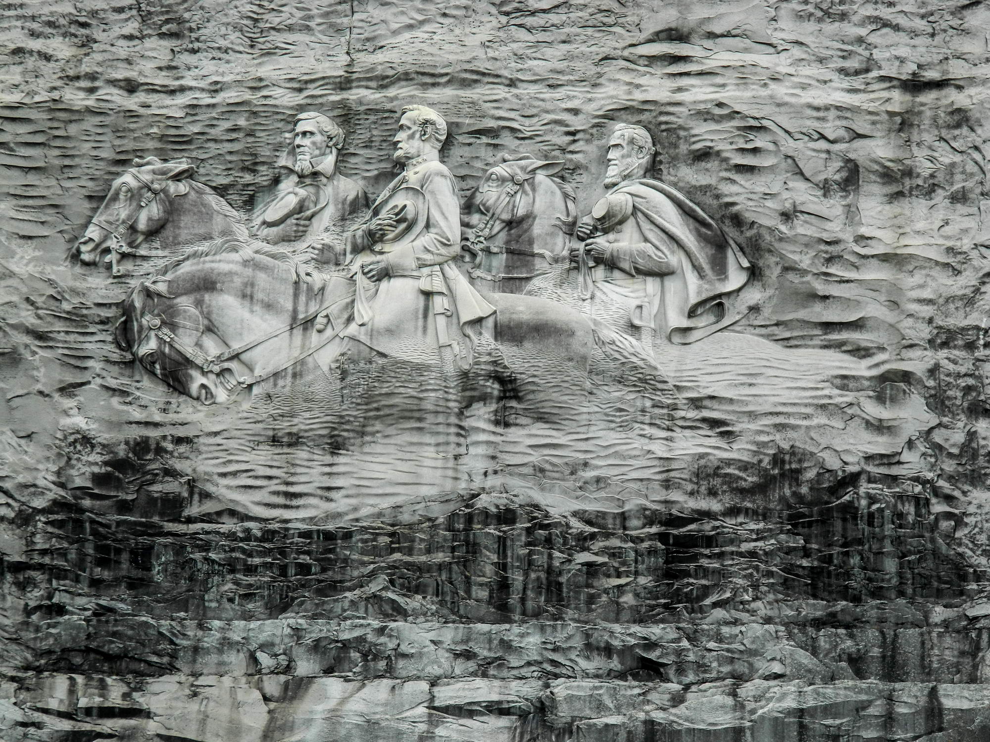 Reliéf vytesaných tří jezdců na koních do žulové stěny Stone Mountain.