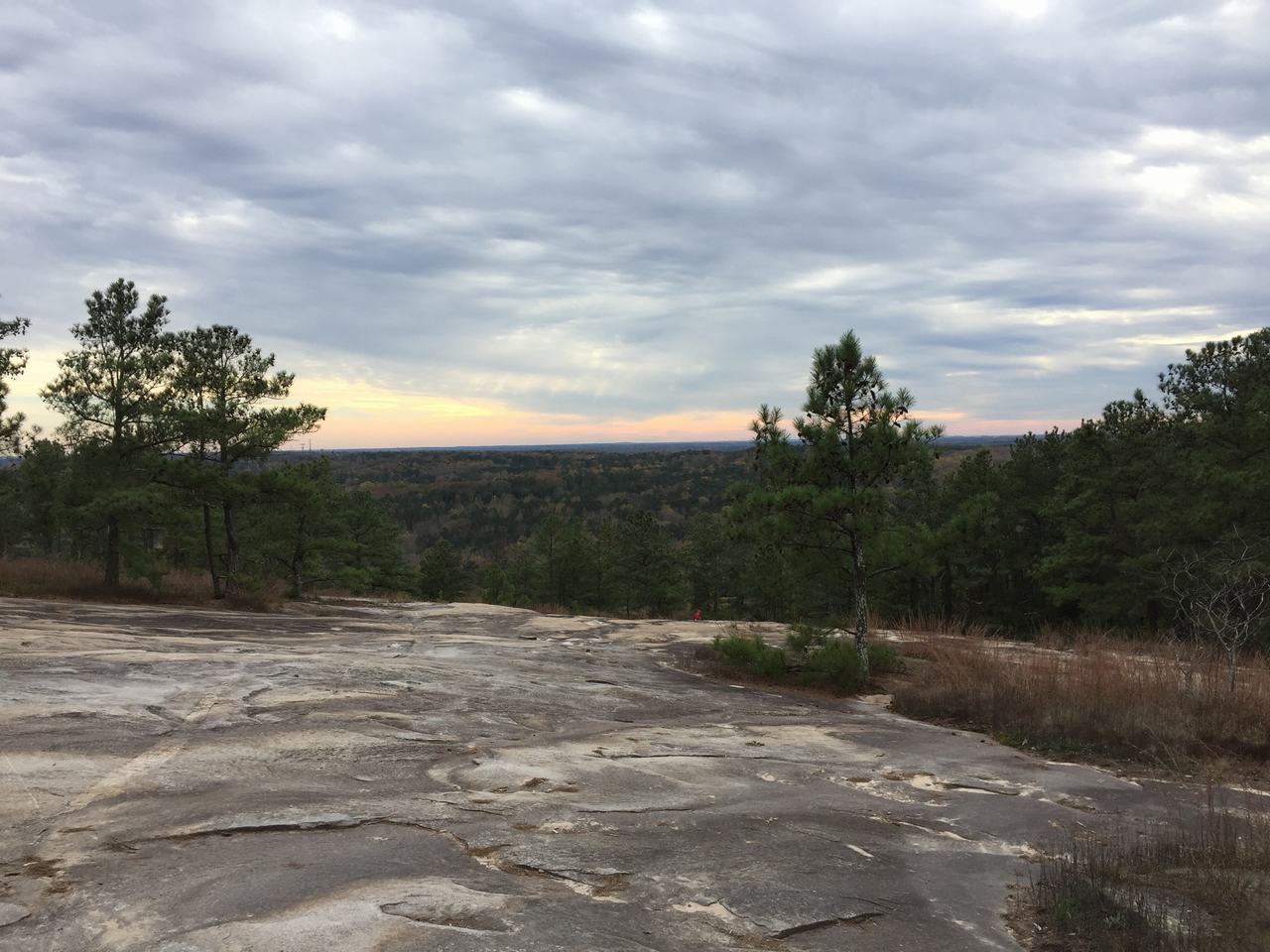Pohled z kamenné plošiny Stone Mountain na lesy a zatažený západ slunce