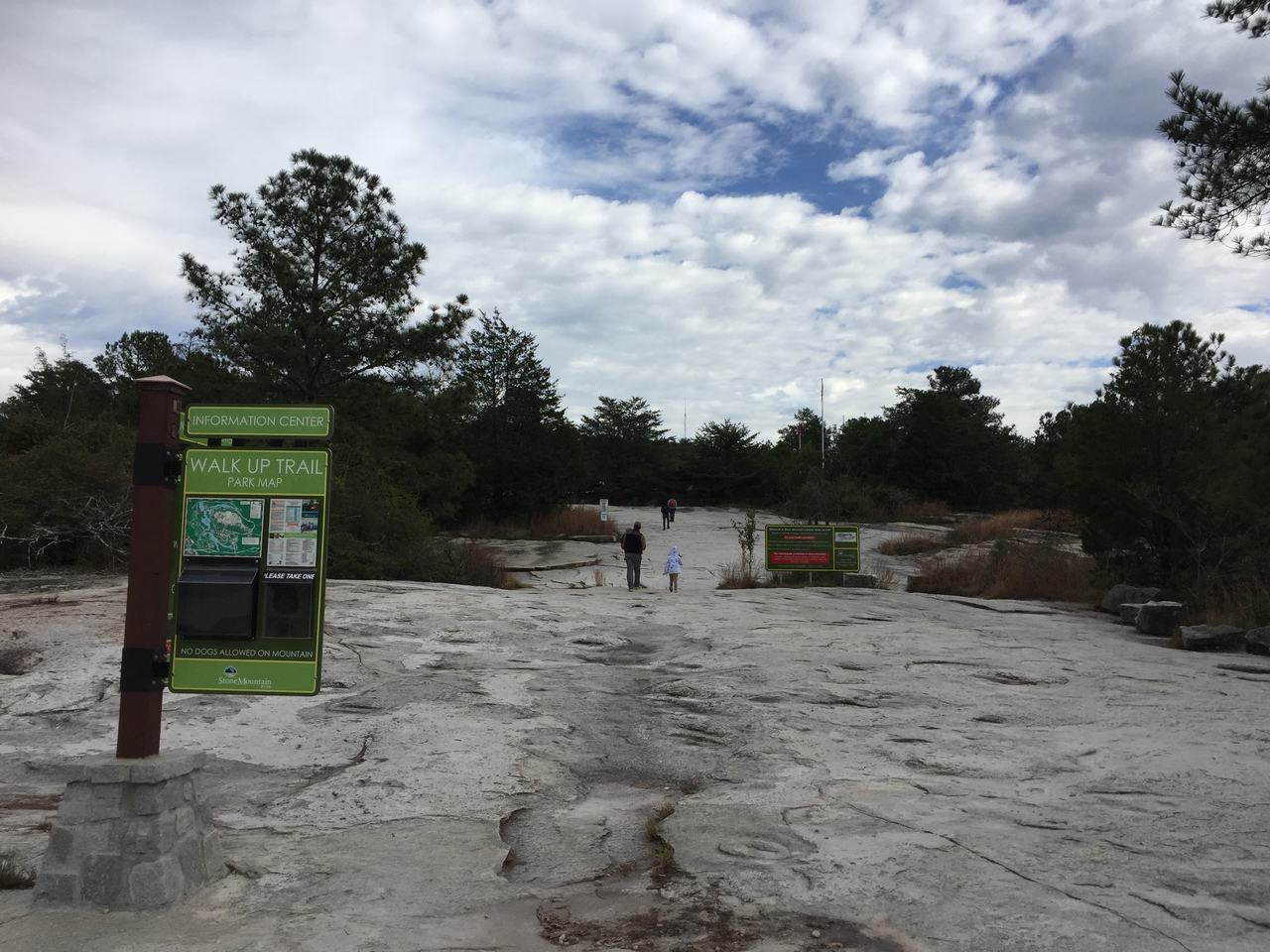Informační cedule WALK UP TRAIL, lidé stoupají po žulové ploše Stone Mountain.