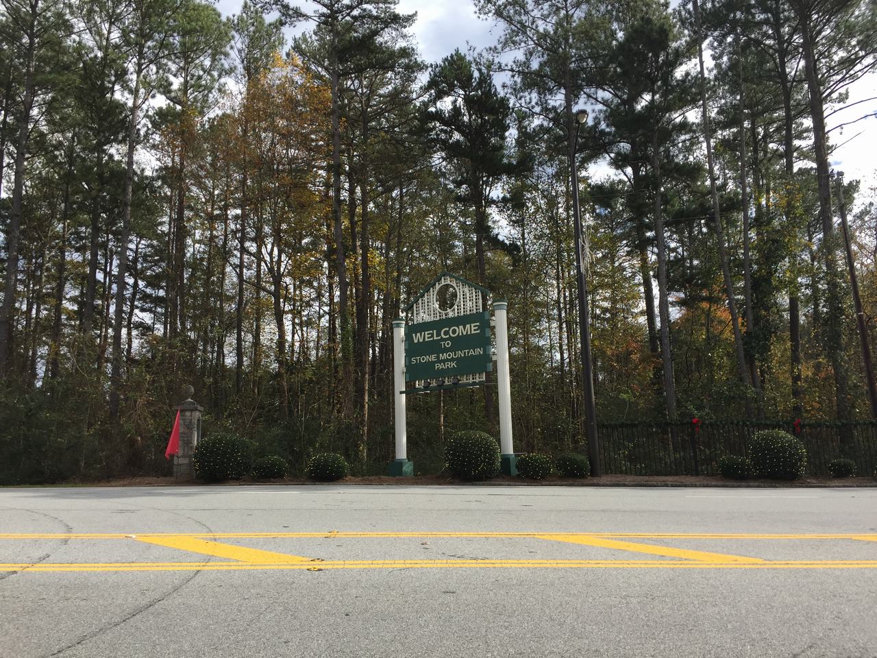 Silniční cedule WELCOME TO STONE MOUNTAIN PARK před lesem u cesty.