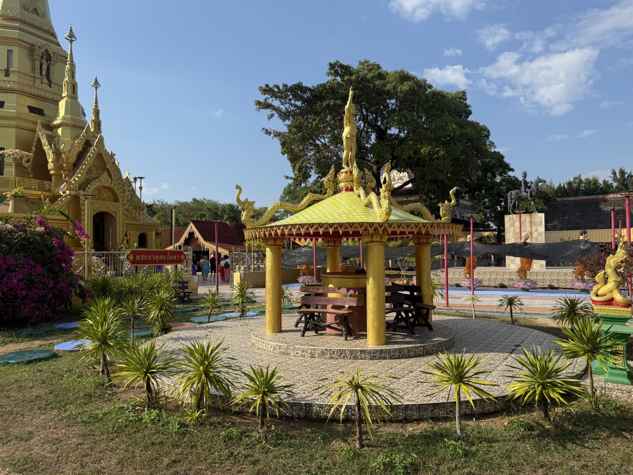Zlatý altánek s nagami a lavicemi před chrámem, nápis วัดคงคาภิมุข