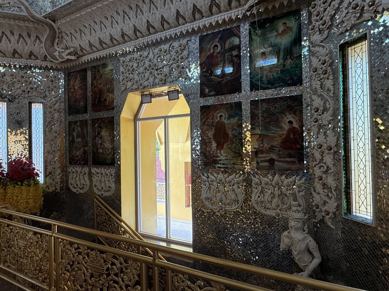 Zrcadlová mozaika chrámu, reliéfy a buddhistické obrazy kolem dveří a oken.