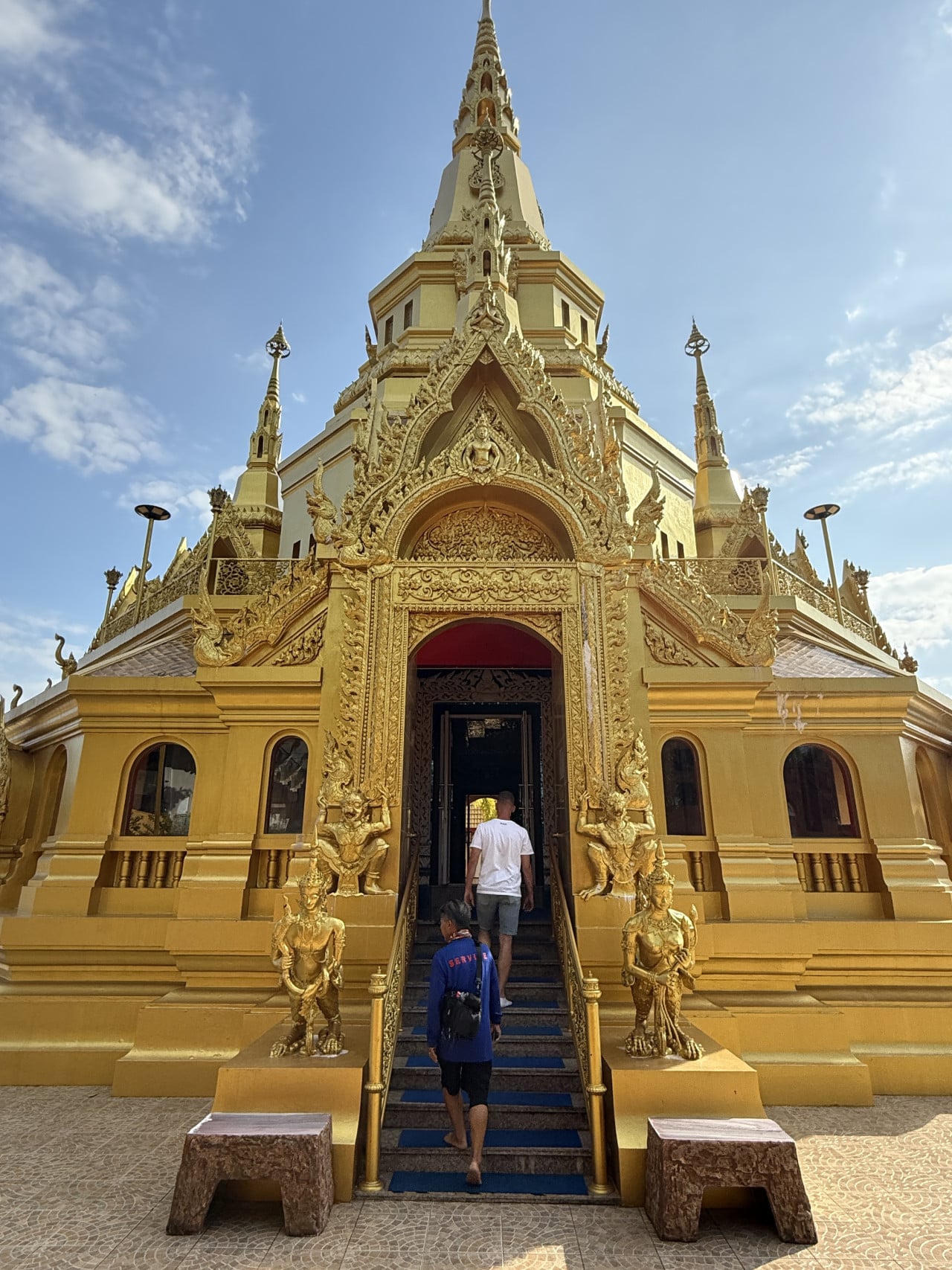 Zlatý chrám Wat Kongka Phimuk, dva návštěvníci stoupají po schodech ke vchodu