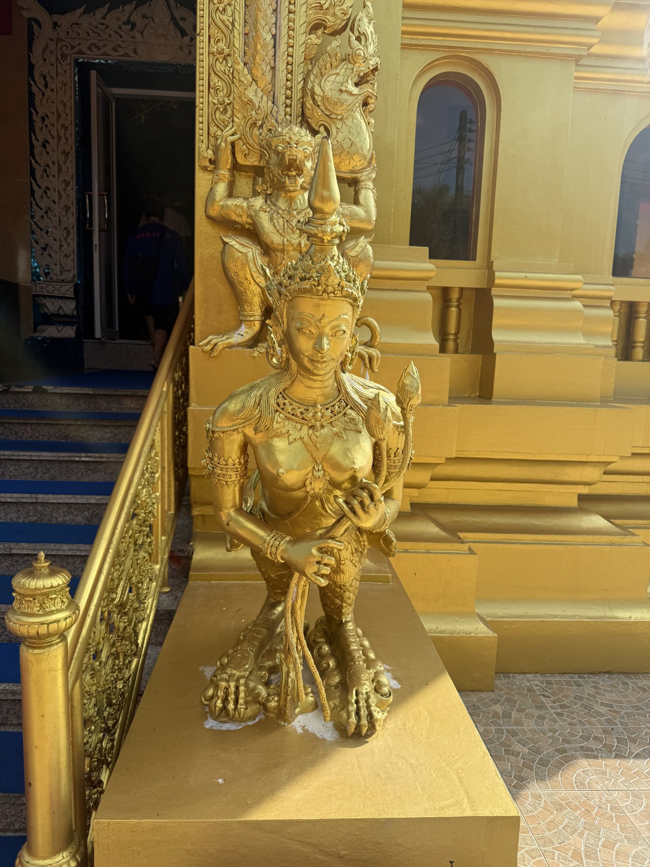 Zlaté sochy mytických bytostí u schodiště vstupu do chrámu Wat Kongka Phimuk