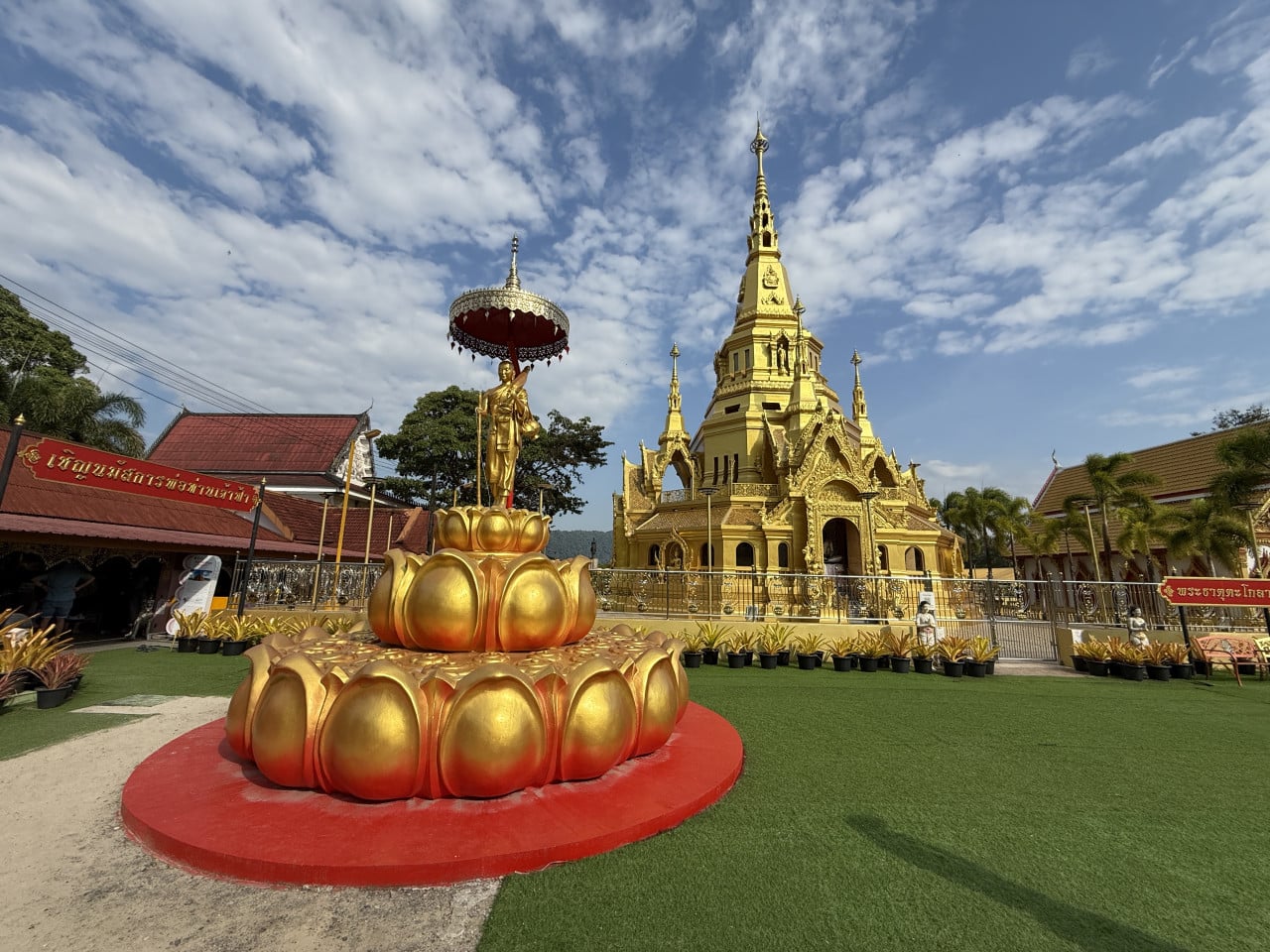 Zlatý chrám Wat Kongka Phimuk a socha na lotosu, kolem thajské nápisy