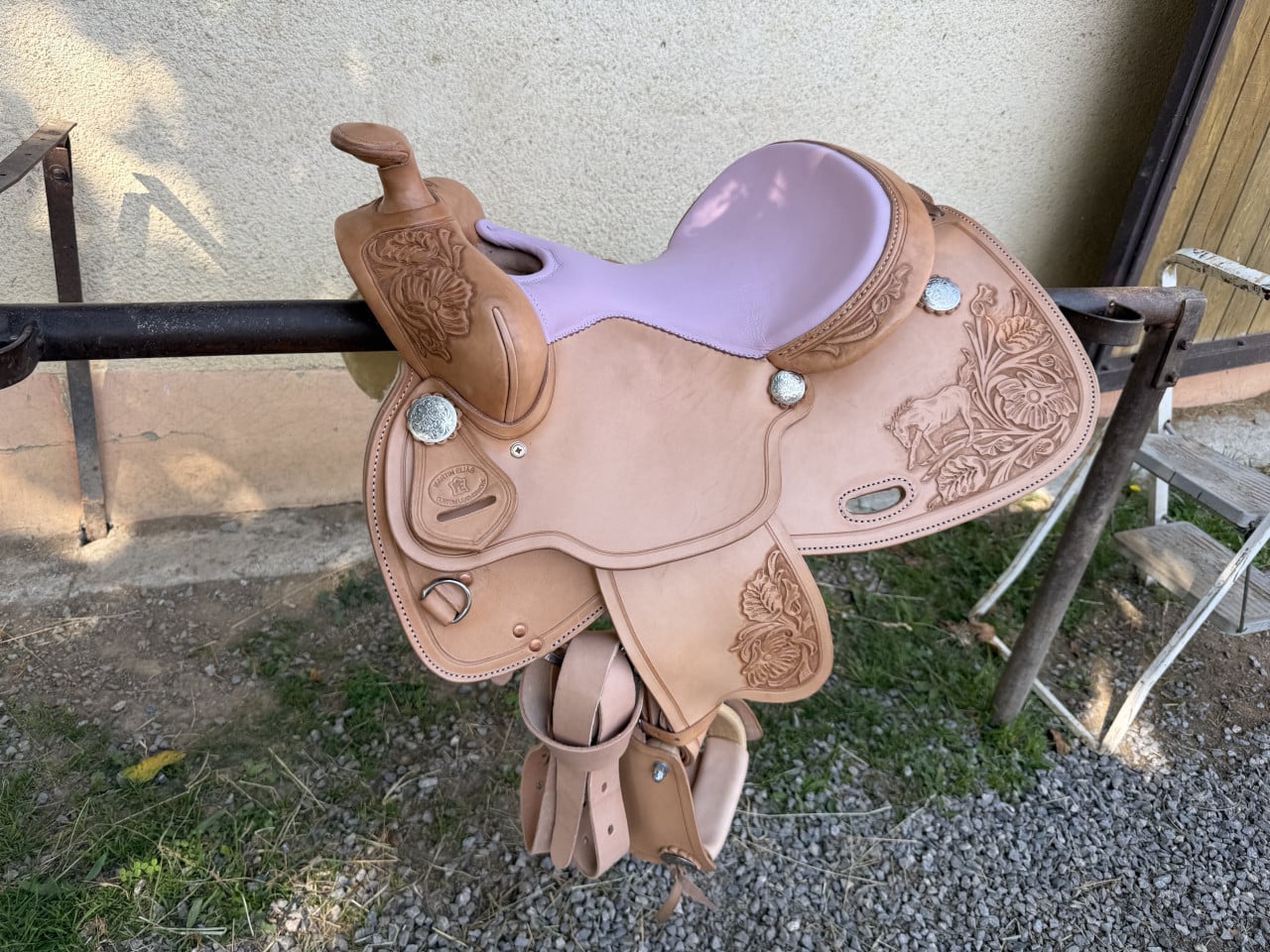 Kožené westernové sedlo na stojanu, zdobené florálním reliéfem, logo WESTERN ELLAS.