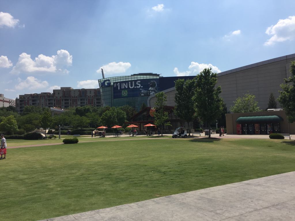 Travnaté náměstí před moderní budovou, oranžové slunečníky, nápis #1 IN U.S.