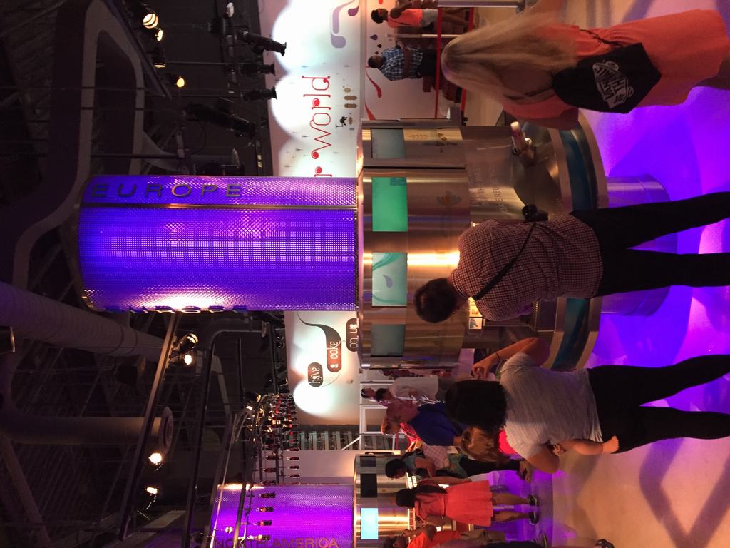 Návštěvníci u ochutnávky, fialový válec EUROPE, nápis have a coke on us