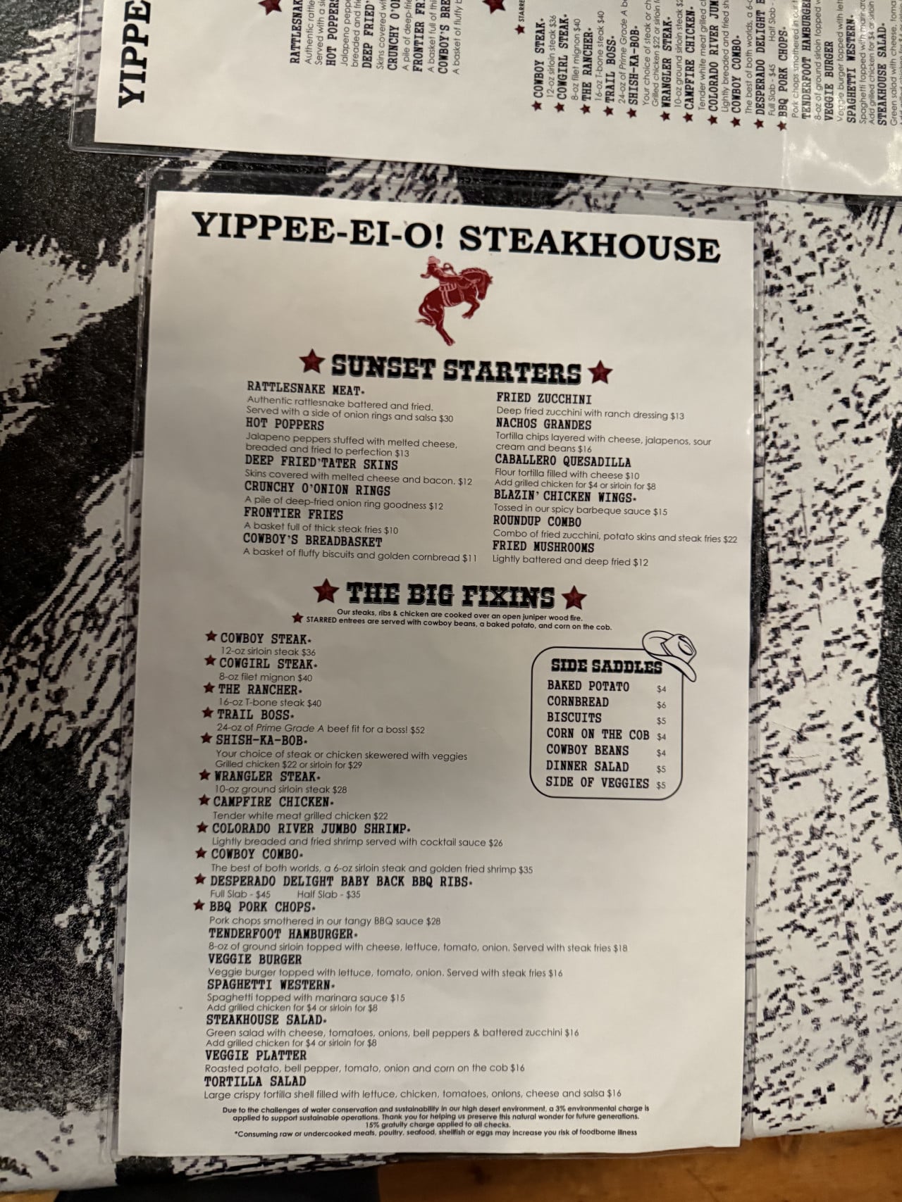 Menu restaurace Yippee-Ei-O! Steakhouse s nabídkou steaků, příloh a chřestýšího masa.