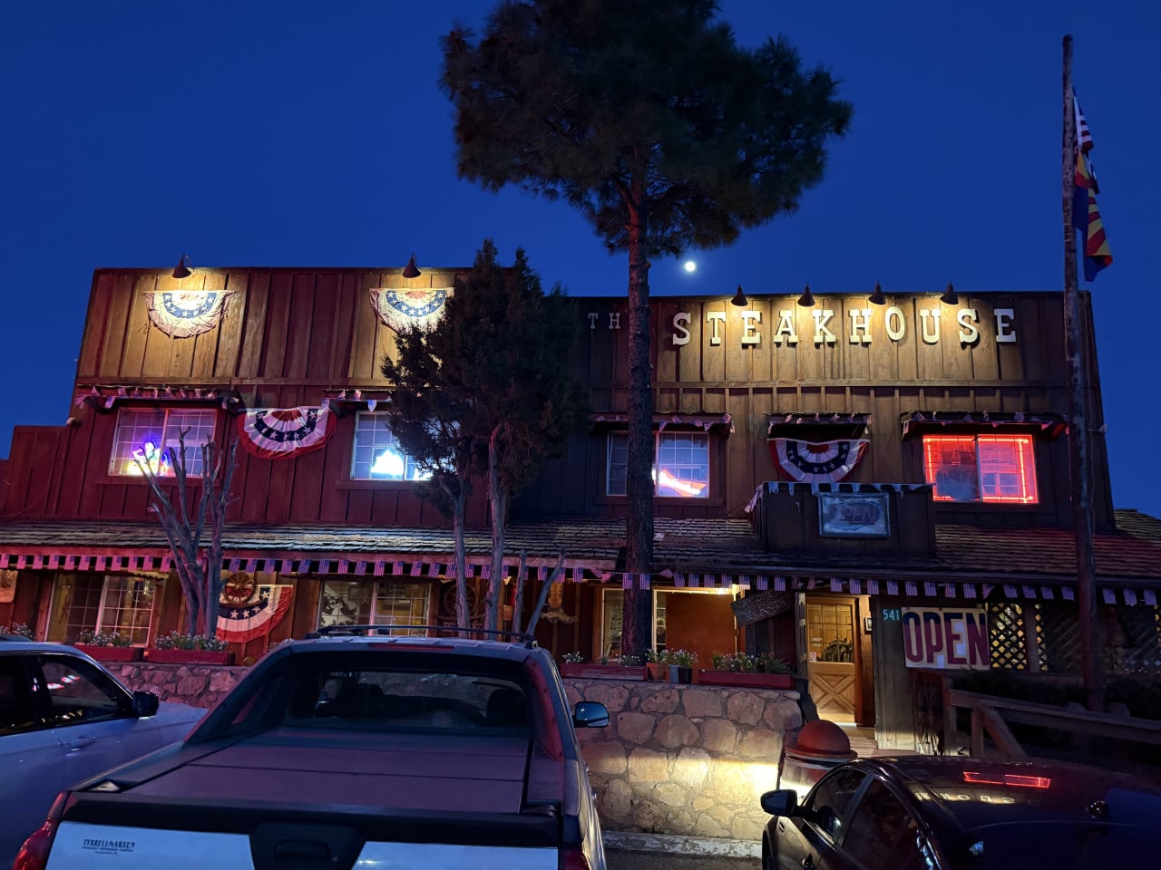 Večerní fasáda Yippee-Ei-O! Steakhouse s nápisem STEAKHOUSE a světelným OPEN.