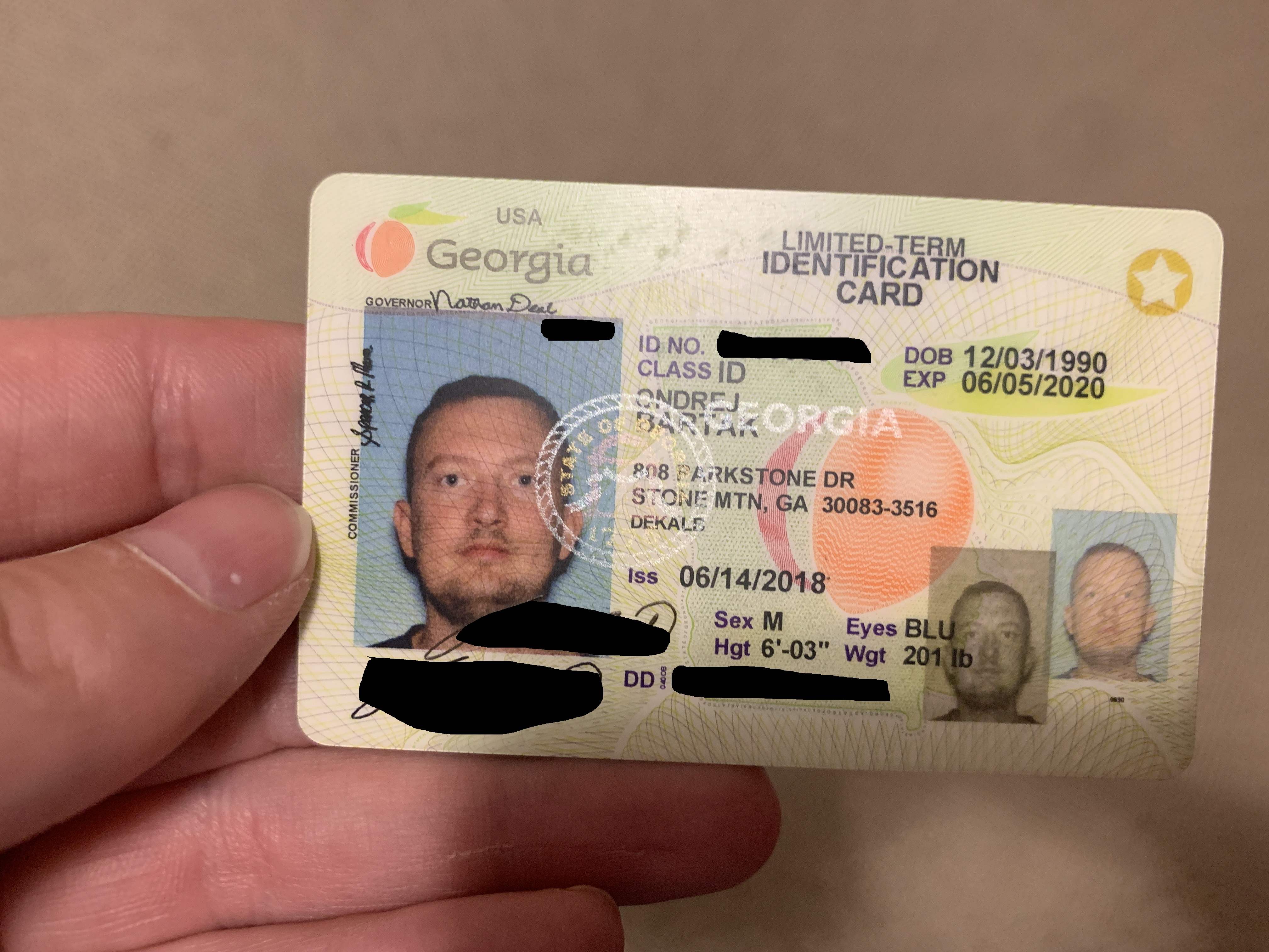 Ruka drží průkaz USA Georgia s fotografií, nápis LIMITED-TERM IDENTIFICATION CARD