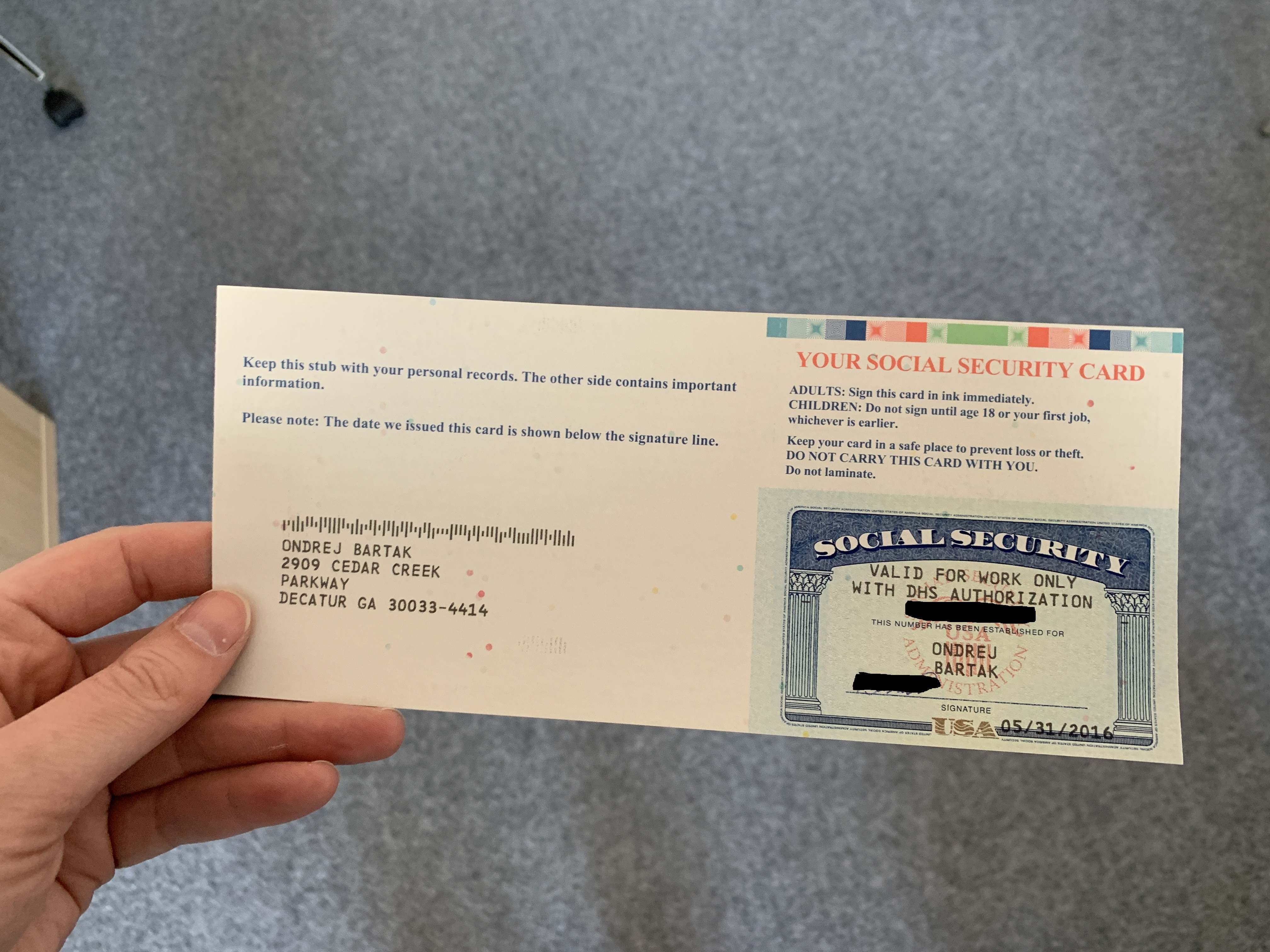 Ruka drží dopis s kartou: YOUR SOCIAL SECURITY CARD, VALID FOR WORK ONLY