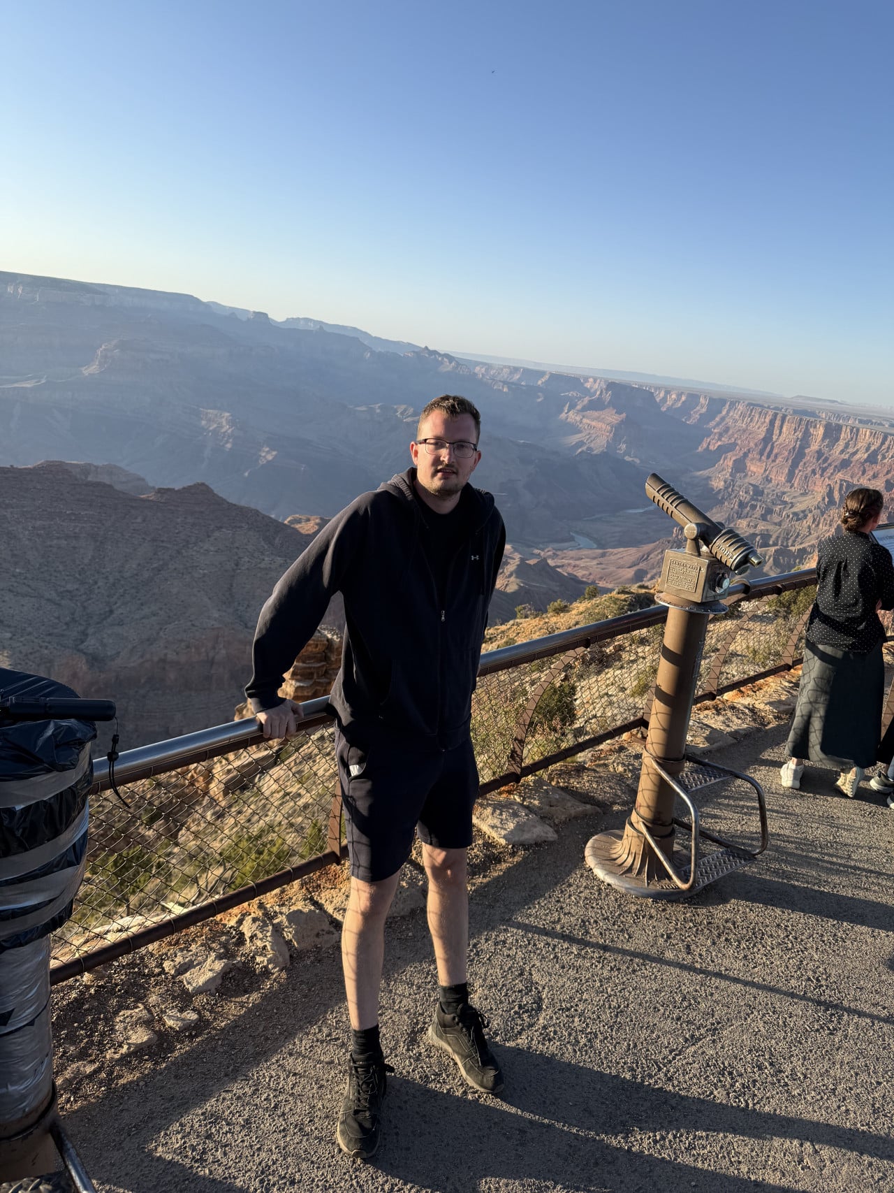 Západ slunce osvětlující hluboký kaňon s vrstvami červených skal v Desert View, Grand Canyon.